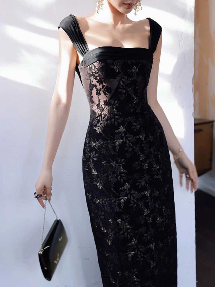 A model wearing a black, floral patterned, bodycon dress with hand-pleated shoulder straps and a fitted waist.