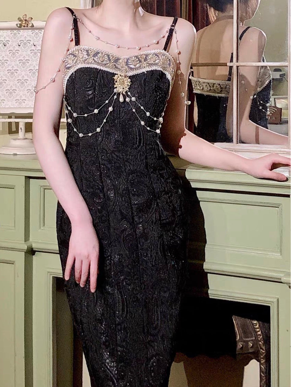 A model wearing a luxurious Baroque-inspired mermaid dress with gold weaving, a detachable brooch, and intricate lace details.