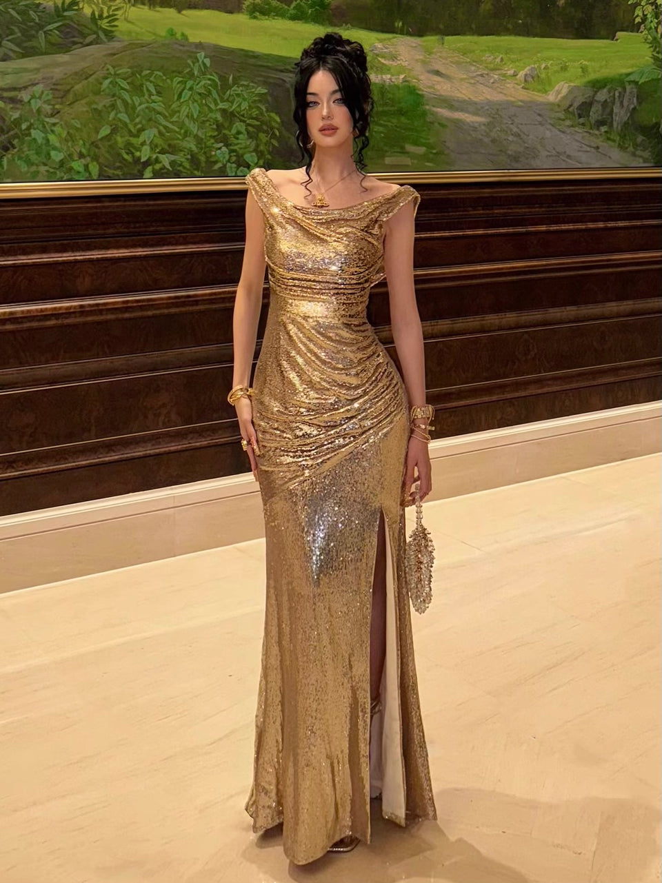 A woman in a luxurious gold gown with sequins, featuring a plunging neckline, V-back, and a slit along the hem.
