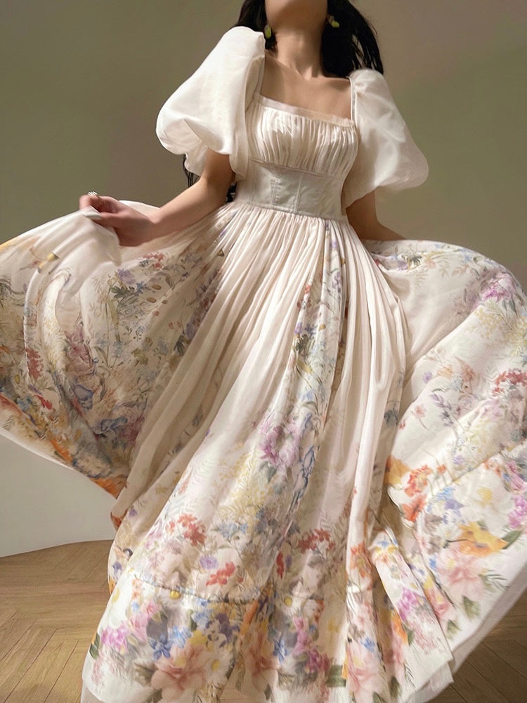 A woman wearing a floral maxi dress with a square neckline and puff sleeves.