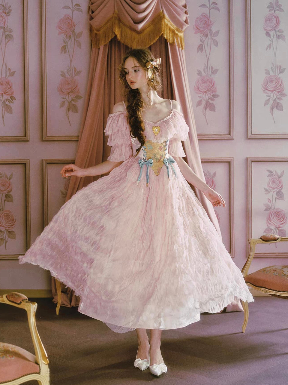 Woman in a vintage-style dress standing in a room with floral wallpaper.